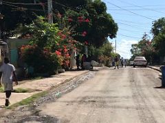 12B Looking down 4th Street with people milling about and some beautiful colourful flowers Trench Town Kingston Jamaica